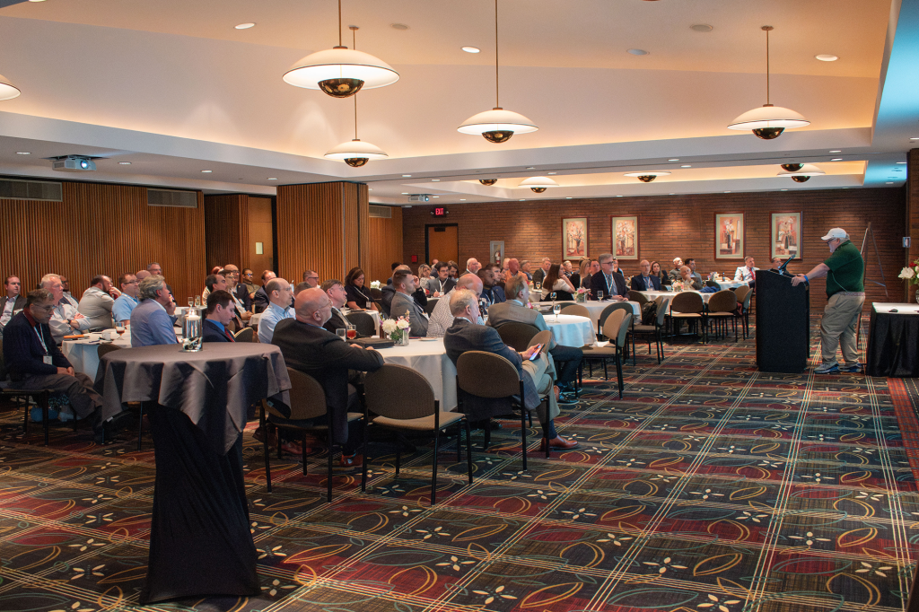 People sitting at round tables listening to a presentation.