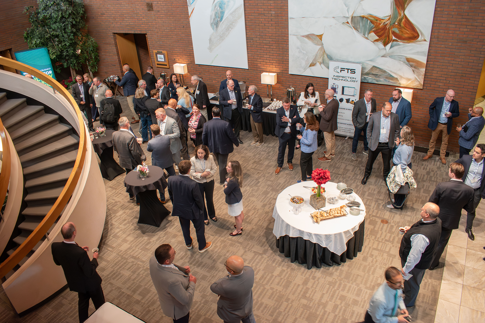 A top down view of a lobby full of people dressed nicely at an evening event.